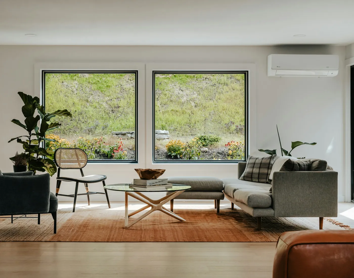 A bright modern living room with a wall-mounted ductless mini-split above the windows