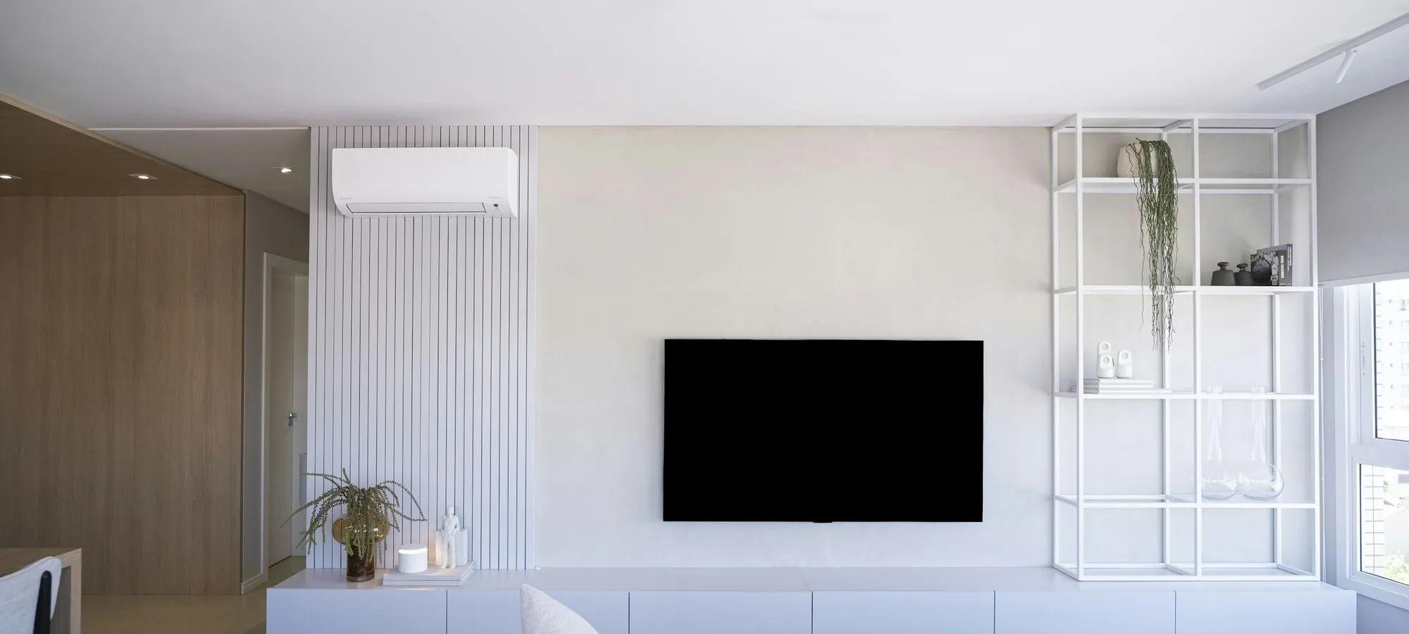 A white modern living room with a ductless mini-split mounted high on the wall